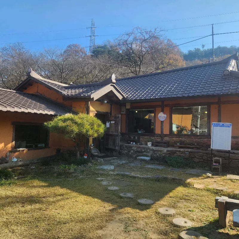 초가랑의 외부 전경: 기와지붕과 흙담이 어우러진 고즈넉한 한옥의 모습