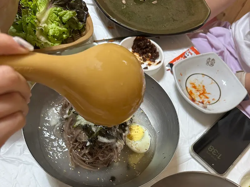 동치미 육수를 부어 물 막국수로 즐기는 모습