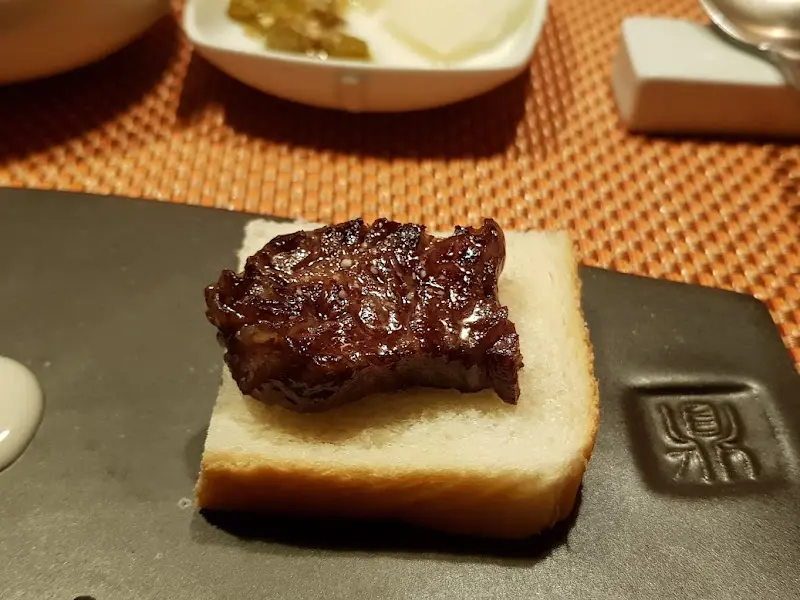 한우 조각을 올린 토스트 한 입