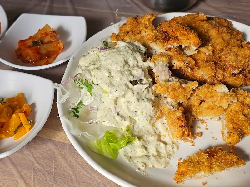 커다란 접시에 돈가스와 샐러드가 함께 담겨 나온 모습