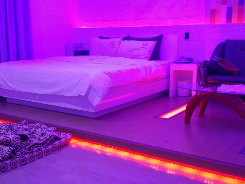 침대 옆 협탁과 테이블이 놓여진 객실 전경