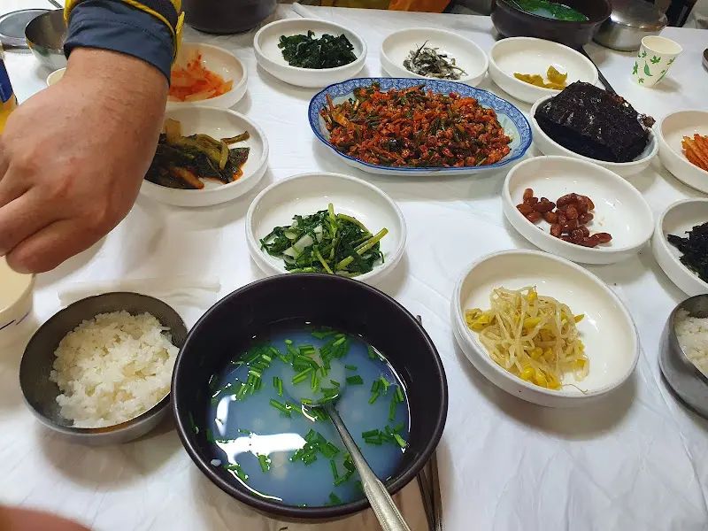 재첩회와 다양한 밑반찬이 놓인 테이블