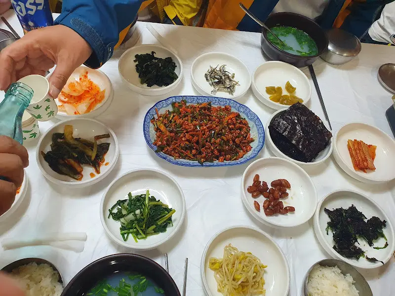 재첩회와 밑반찬, 술잔이 놓인 테이블