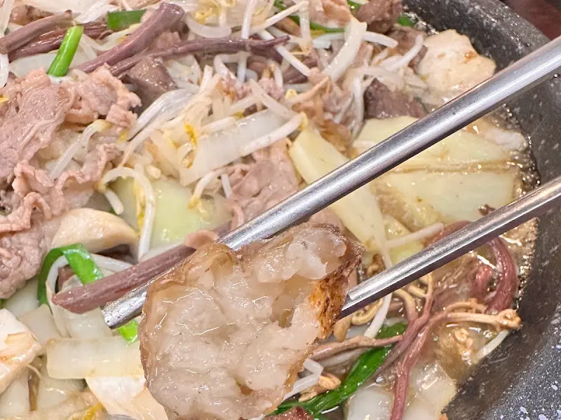 젓가락으로 곱창을 집어 올리는 모습