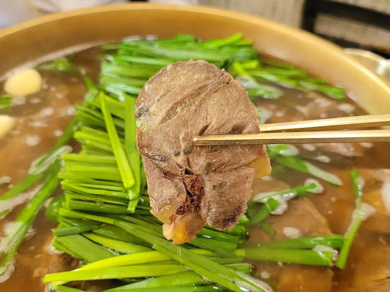젓가락으로 들어올린 곰탕 고기