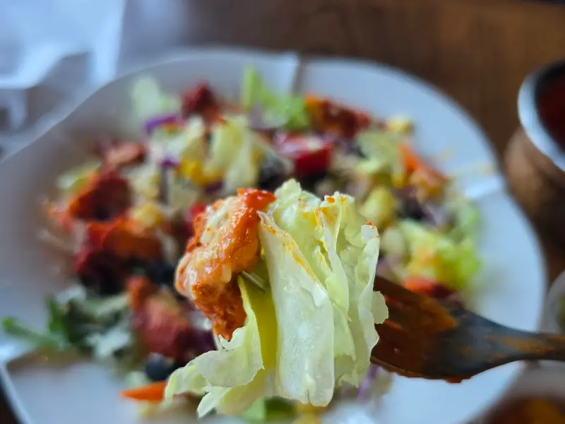 포크로 탄두리 치킨 샐러드를 들어올리는 모습