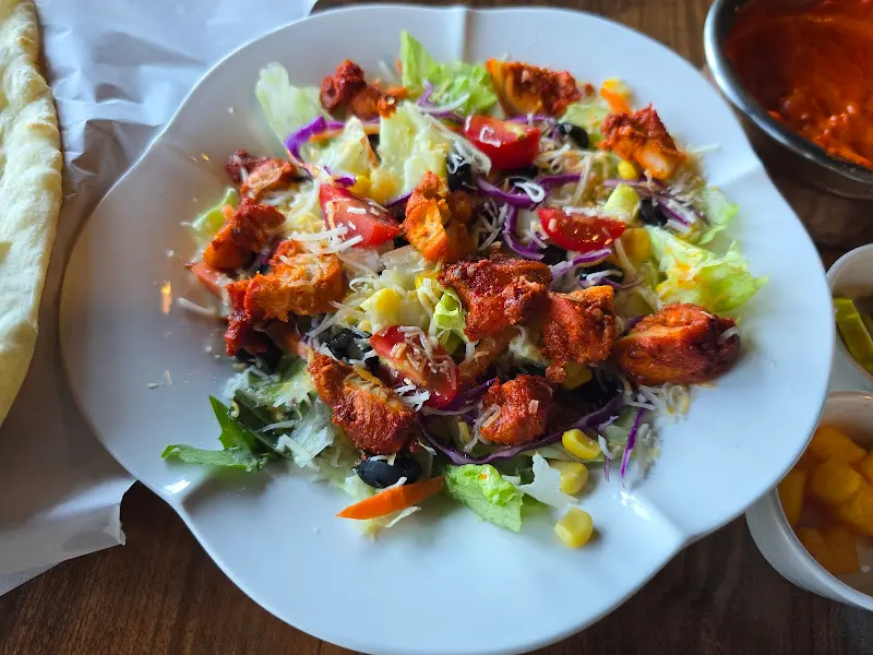 테이블 위에 놓인 탄두리 치킨 샐러드 전체 샷