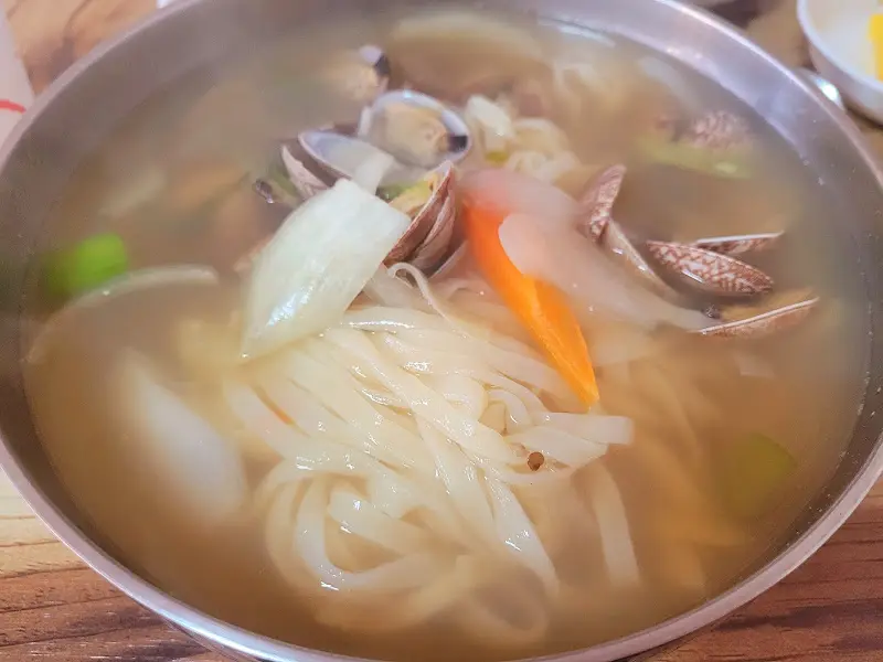 바지락 칼국수의 면발과 국물이 클로즈업된 사진