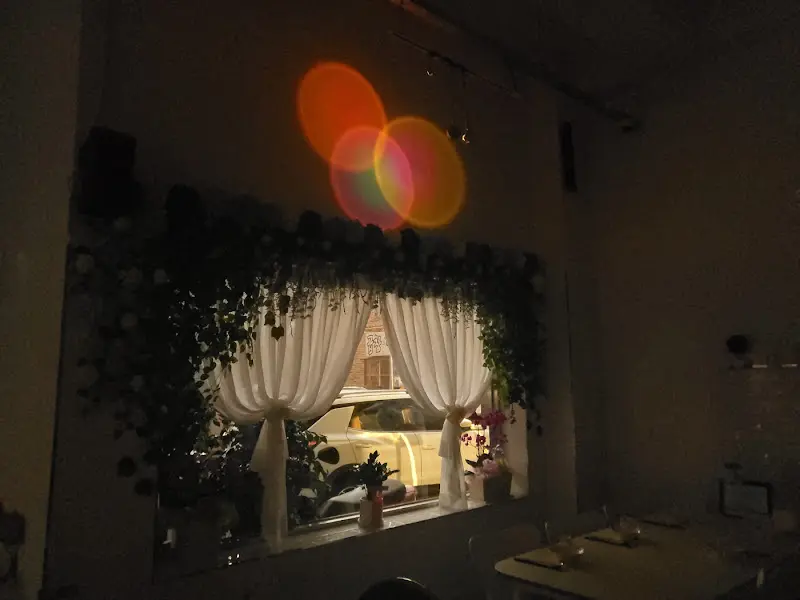 커튼이 드리워진 창가 좌석 위로 둥근 조명이 비추는 모습