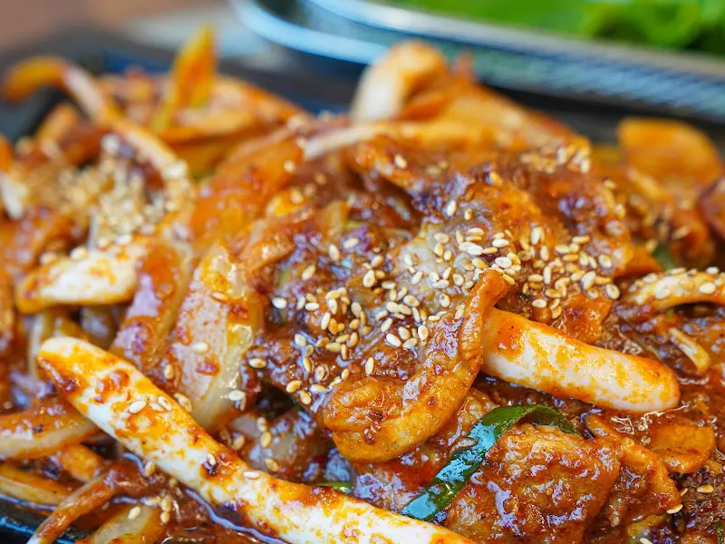 접사로 촬영된 오삼불고기, 윤기가 흐르는 양념과 깨소금이 음식의 먹음직스러움을 더한다.