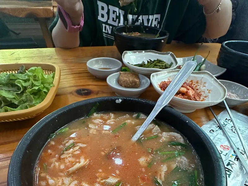 돼지국밥에 다진 마늘과 고추를 듬뿍 넣어 얼큰하게 즐기는 모습