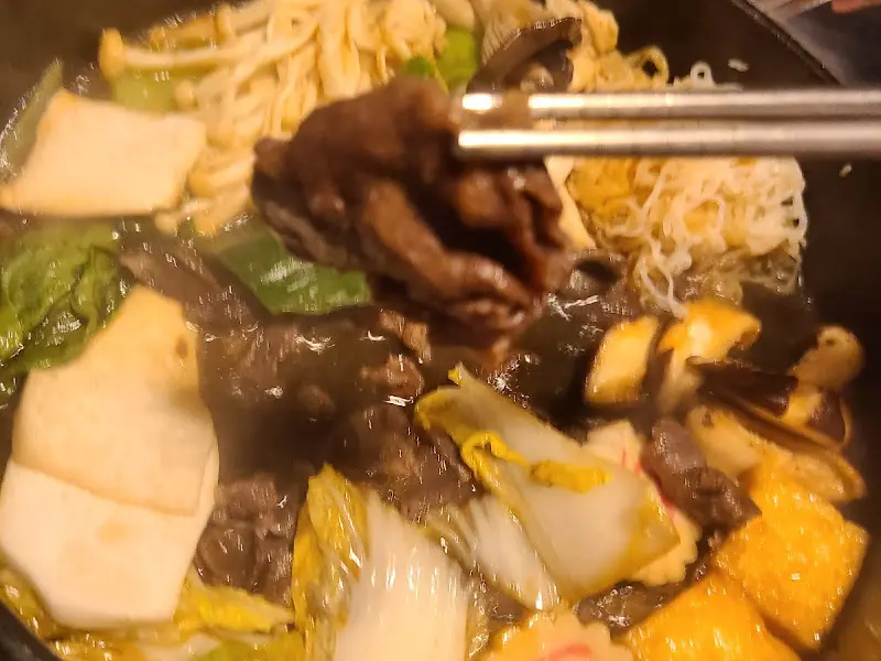 젓가락으로 집어 올린 스키야키 고기