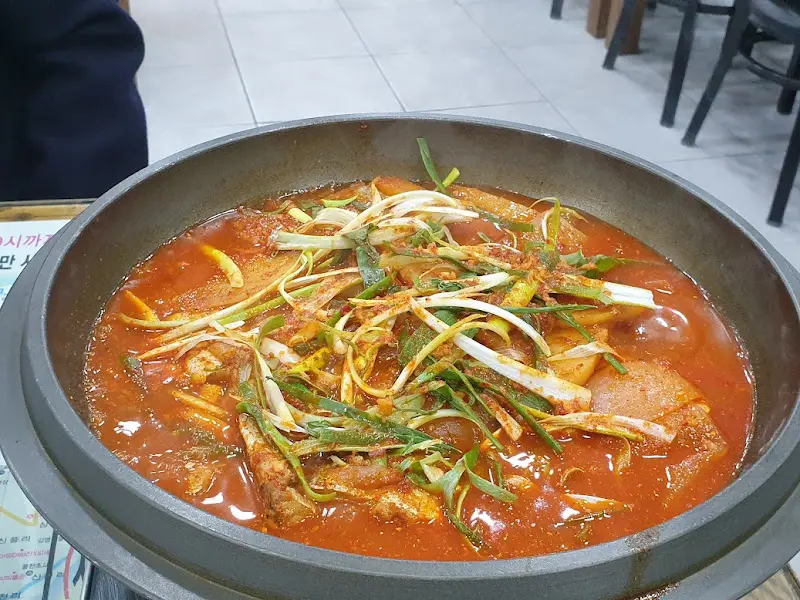 테이블 위에 놓인 갈치조림 냄비의 모습. 파가 듬뿍 올려져 있다.