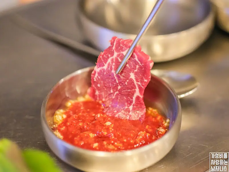 한우를 소스에 찍어 먹는 모습