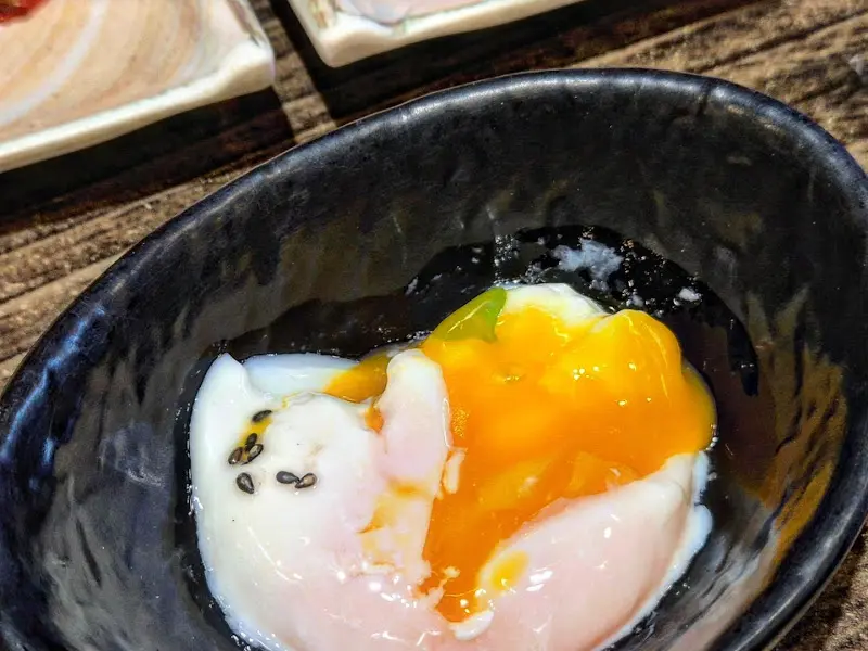 검은 그릇에 담긴 수란의 모습