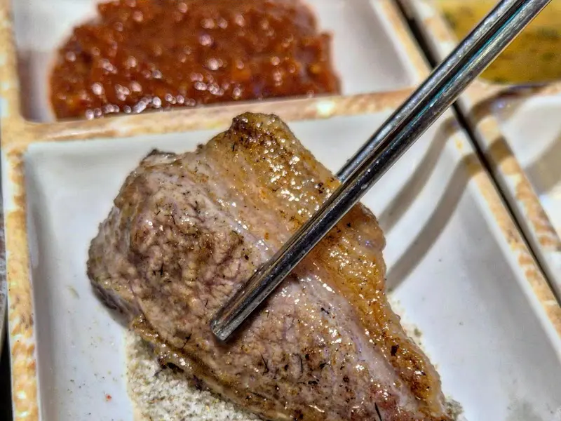 잘 구워진 삼겹살을 멜젓에 찍어먹는 모습