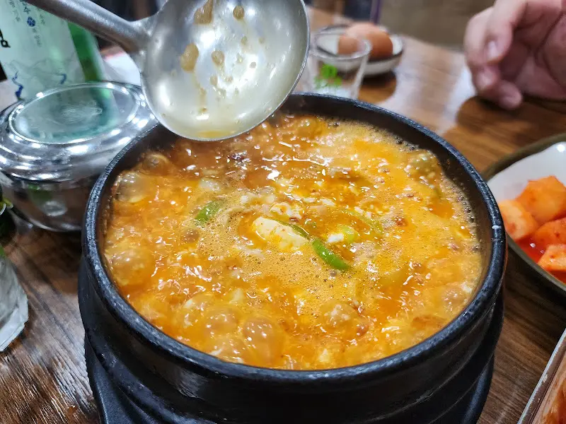 국자로 순두부찌개를 뜨는 모습
