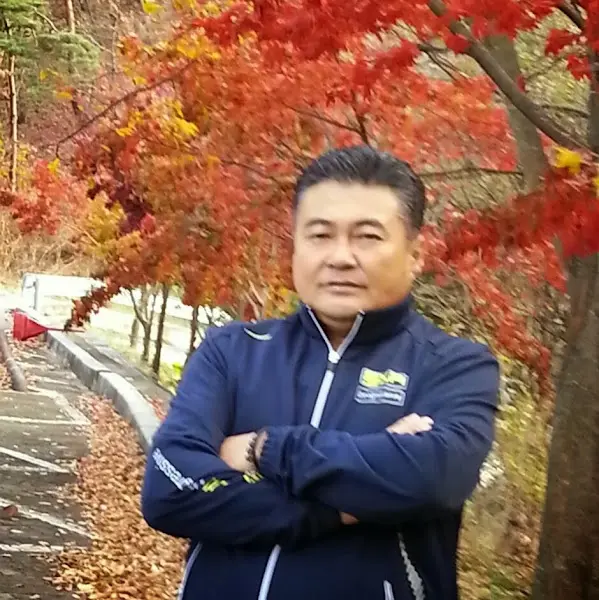 가을 풍경을 배경으로 서 있는 중년 남성