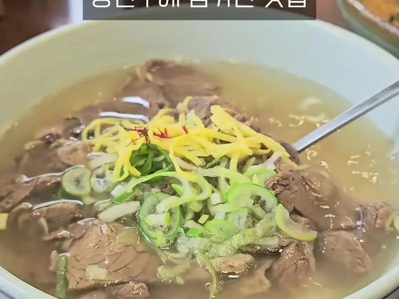 뽀얀 국물 위로 얇게 썰린 한우와 송송 썬 파, 그리고 노란 지단이 얹어진 한우 곰탕