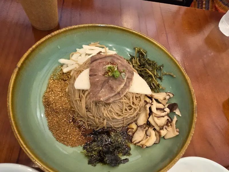 메밀 면 위로 갖가지 나물과 버섯, 김 가루, 들깨가 듬뿍 올려진 비비작작 골동면