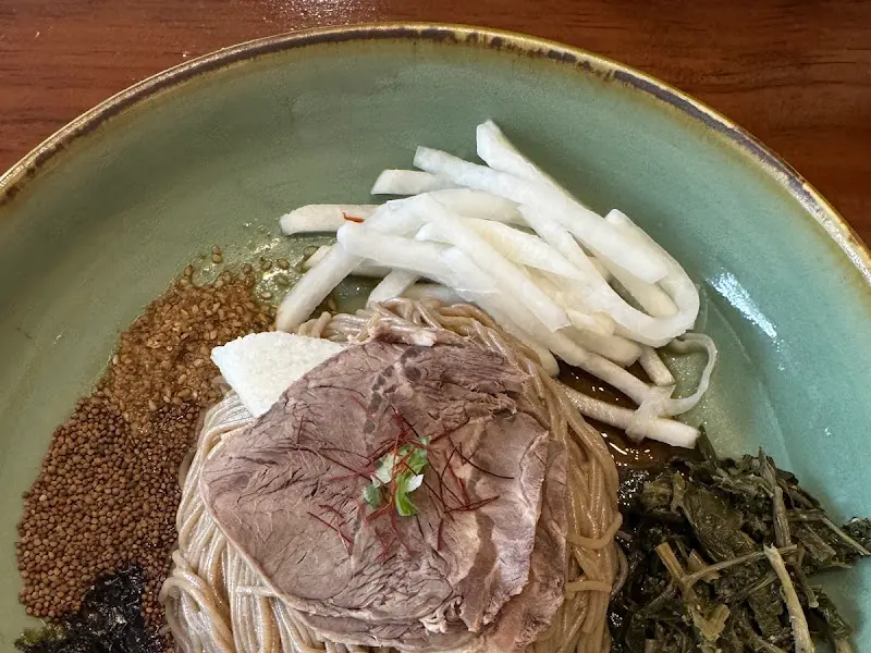 메밀 면 위로 갖가지 나물과 버섯, 김 가루, 들깨가 듬뿍 올려진 비비작작 골동면