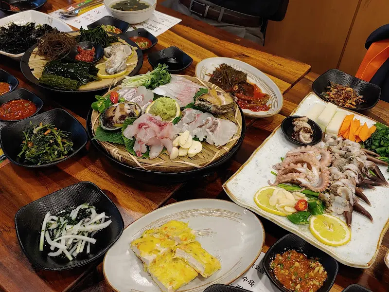 다양한 해산물과 밑반찬이 가득 차려진 테이블