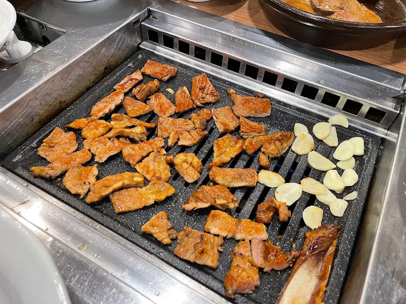 불판 위에서 익어가는 돼지갈비와 마늘