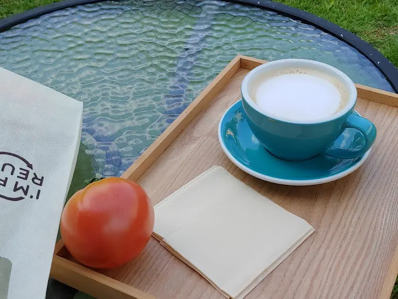 나무 쟁반 위에 놓인 커피와 토마토