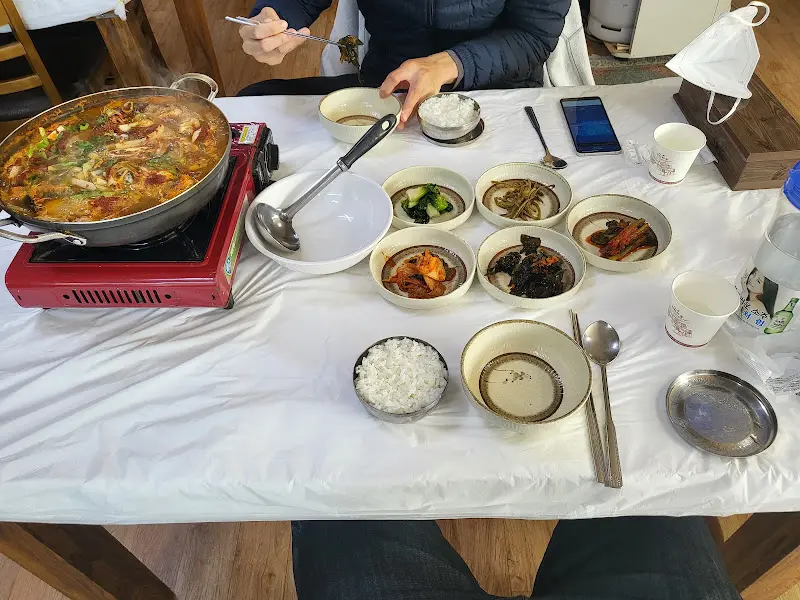 테이블 위에 차려진 가자미 회무침과 물망치 매운탕, 그리고 다양한 반찬들