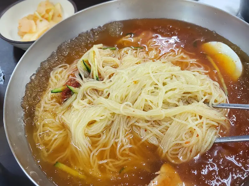 젓가락으로 밀면을 먹는 모습