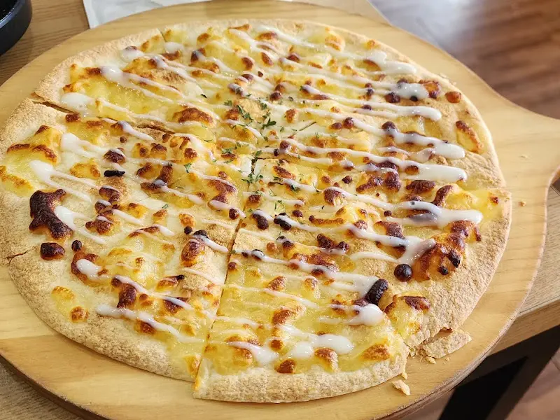 얇은 도우 위에 치즈가 듬뿍 올려진 피자