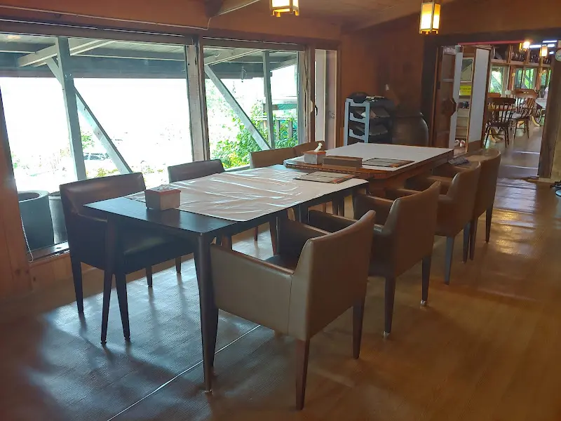 따뜻한 햇살이 들어오는 창가 좌석과 나무 테이블이 놓인 식당 내부