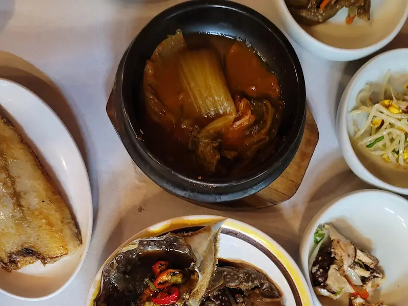 정갈하게 담긴 밑반찬들과 간장게장, 고등어 구이가 놓인 푸짐한 한 상 차림