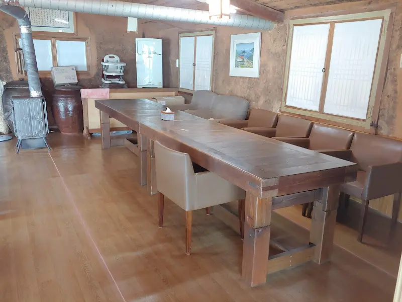 넓은 테이블과 편안한 의자가 놓인 식당 내부 모습