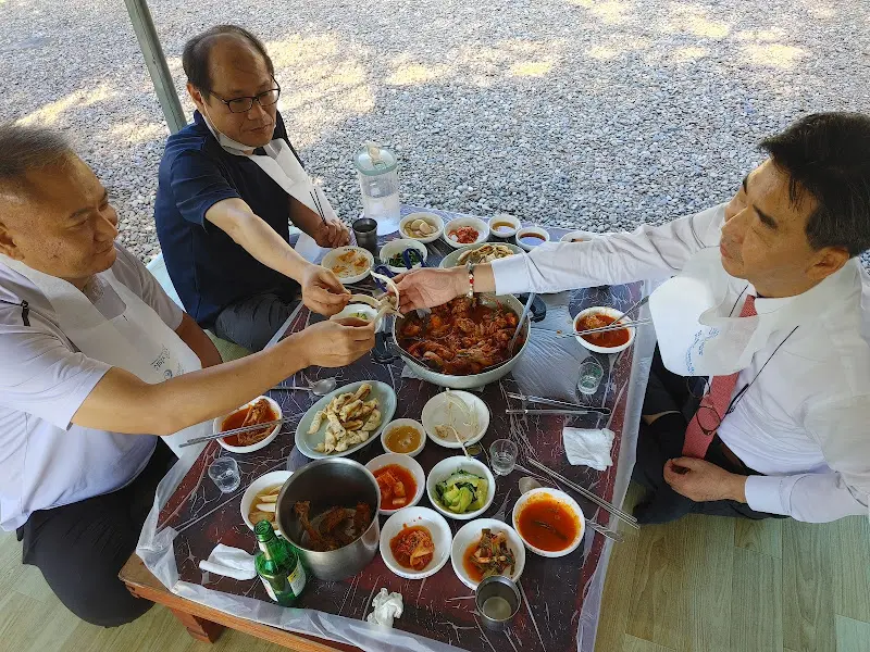 테이블에 둘러앉아 닭볶음탕을 즐기는 사람들