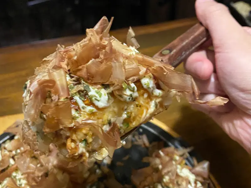 오코노미야키 한 조각을 들어 올리는 모습