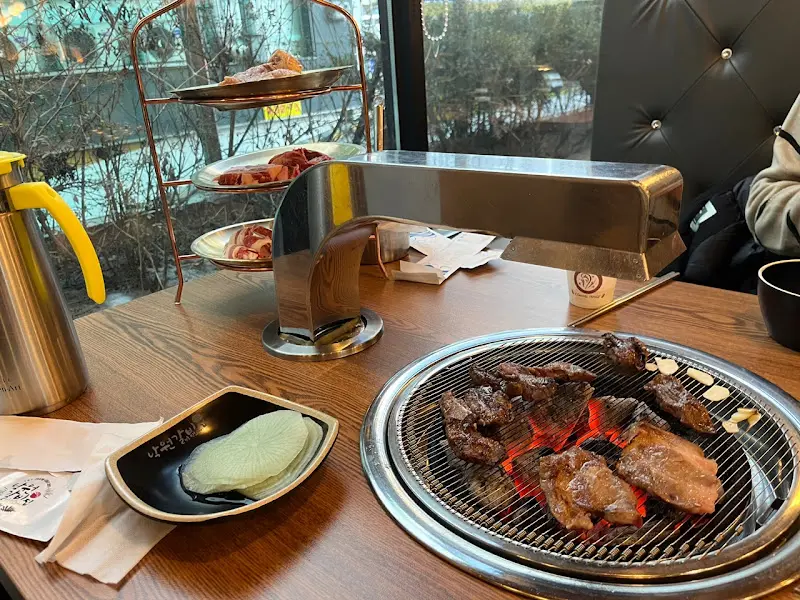 불판 위에서 구워지는 고기와 테이블 세팅