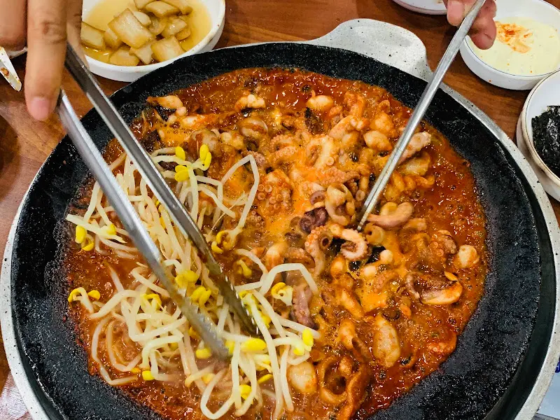 쭈꾸미와 콩나물을 집게로 들어올리는 모습