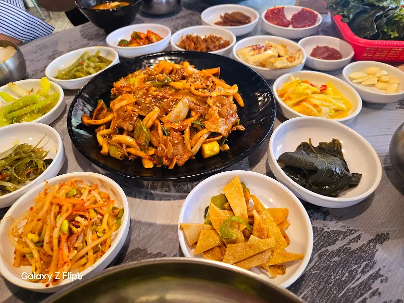 푸짐하게 차려진 제육볶음과 다양한 반찬들