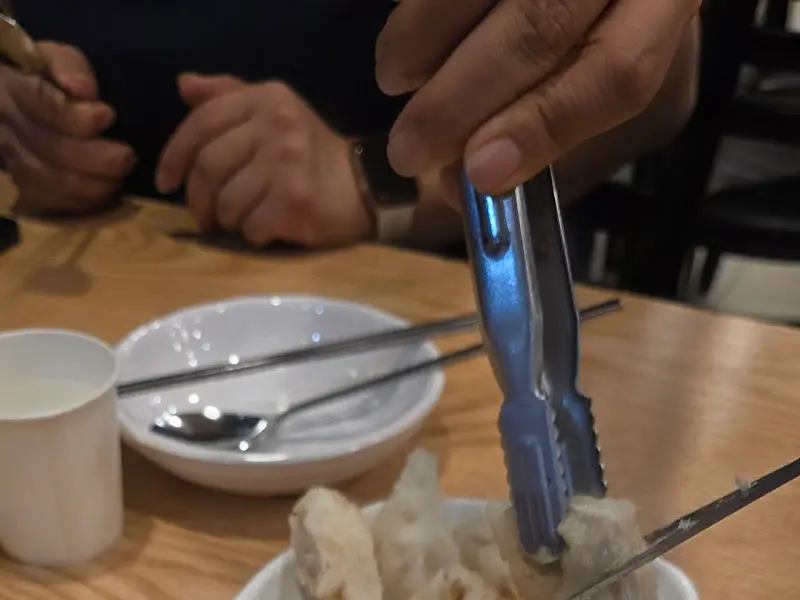 가위와 집게로 탕수육을 자르는 모습