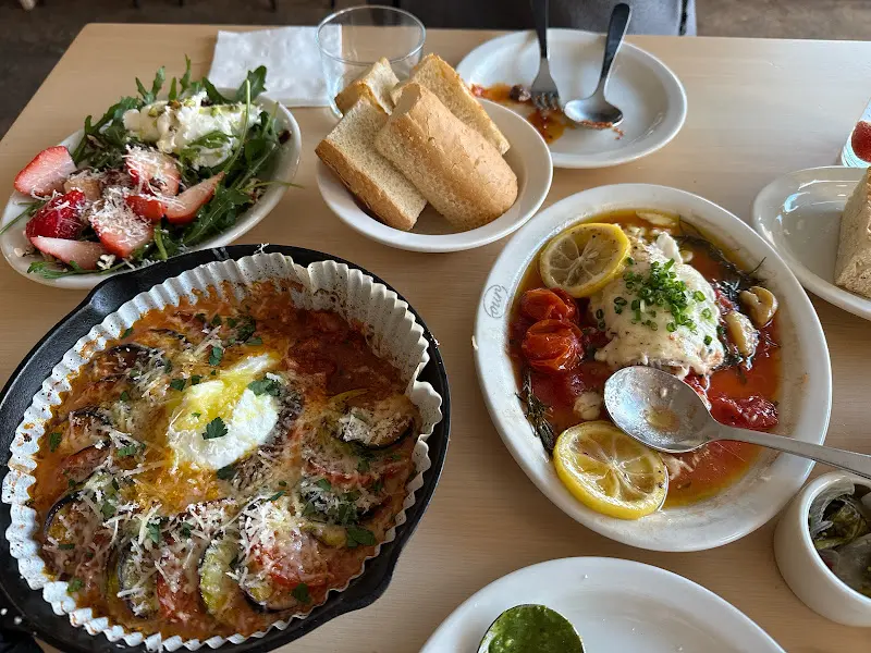 라따뚜이, 샐러드, 빵, 생선 스테이크 등 다양한 메뉴가 놓인 테이블