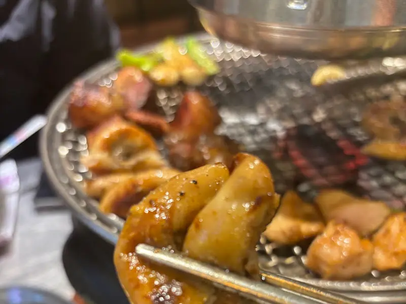 잘 구워진 곱창을 집는 젓가락