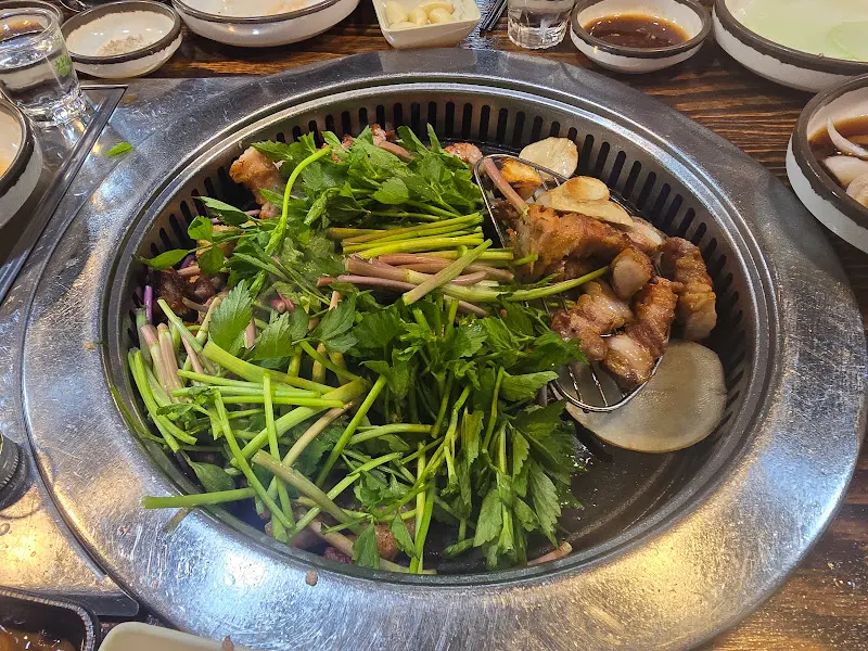 불판 가득 올려진 삼겹살과 미나리