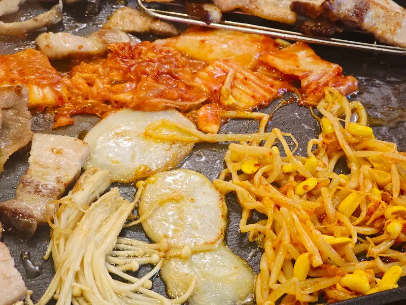 불판 위에서 익어가는 김치와 콩나물