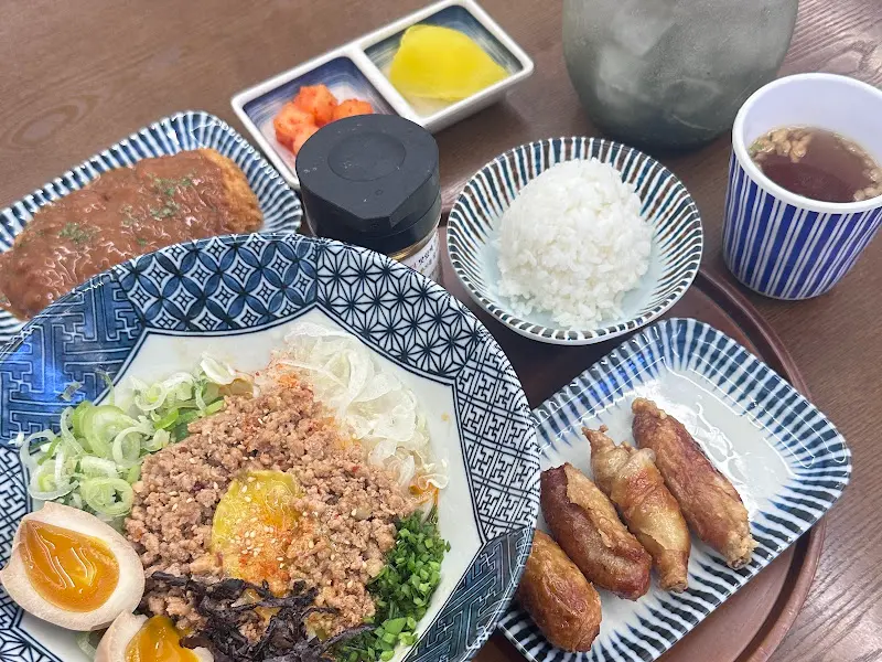 테이블 위에 놓인 마제소바, 닭껍질교자, 밥, 단무지, 소스