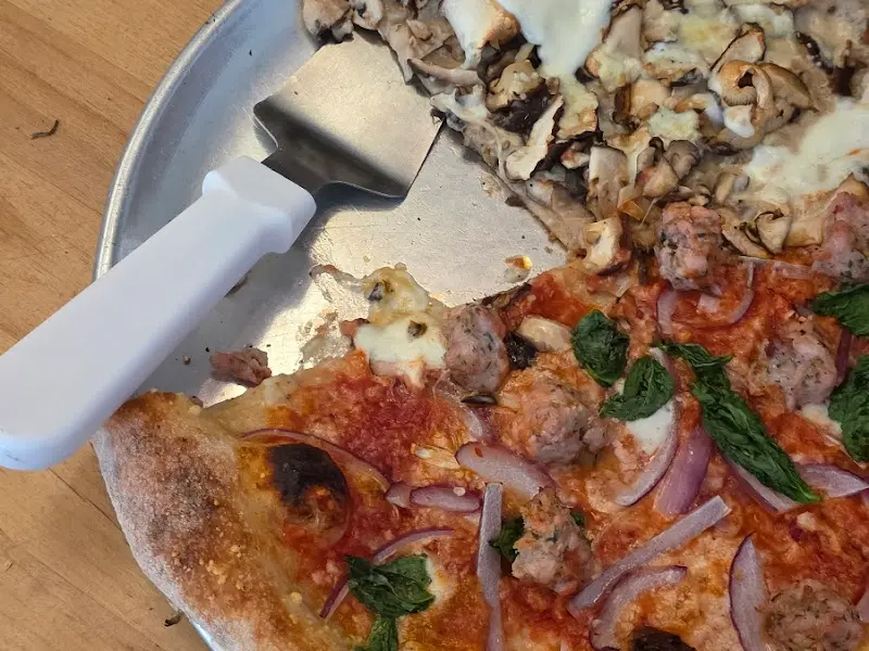 피자 서버로 조각을 덜어낸 카붐 피자의 단면