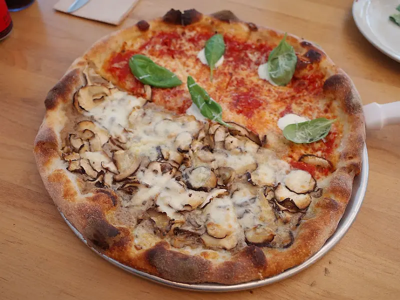 테이블 위에 놓인 하프 앤 하프 피자의 전체적인 모습