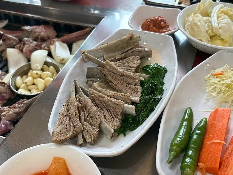 잘 구워진 양갈비와 곁들임 채소들이 정갈하게 담겨 있는 모습