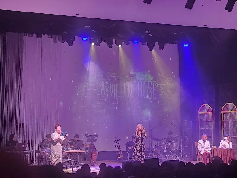 공연이 끝난 후, 무대 위에서 배우들이 관객들에게 인사를 하고 있다. 환호하는 관객들의 모습이 인상적이다.