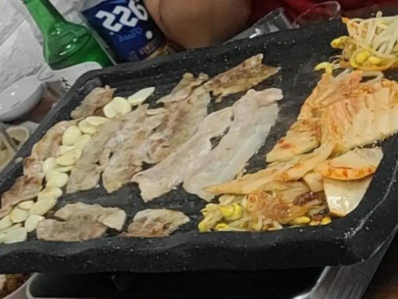 삼겹살과 김치, 마늘이 구워진 불판